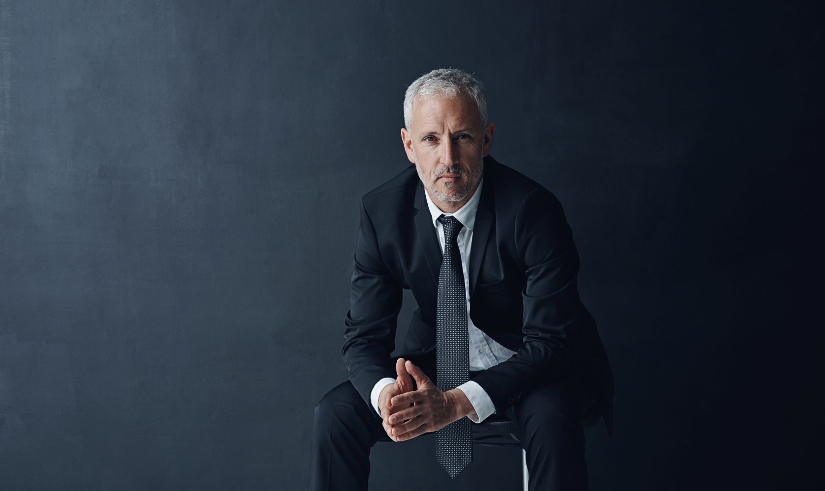man wearing a suit sitting on a chair 