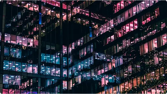 Illuminated modern glass office building grid facade representing data and business intelligence