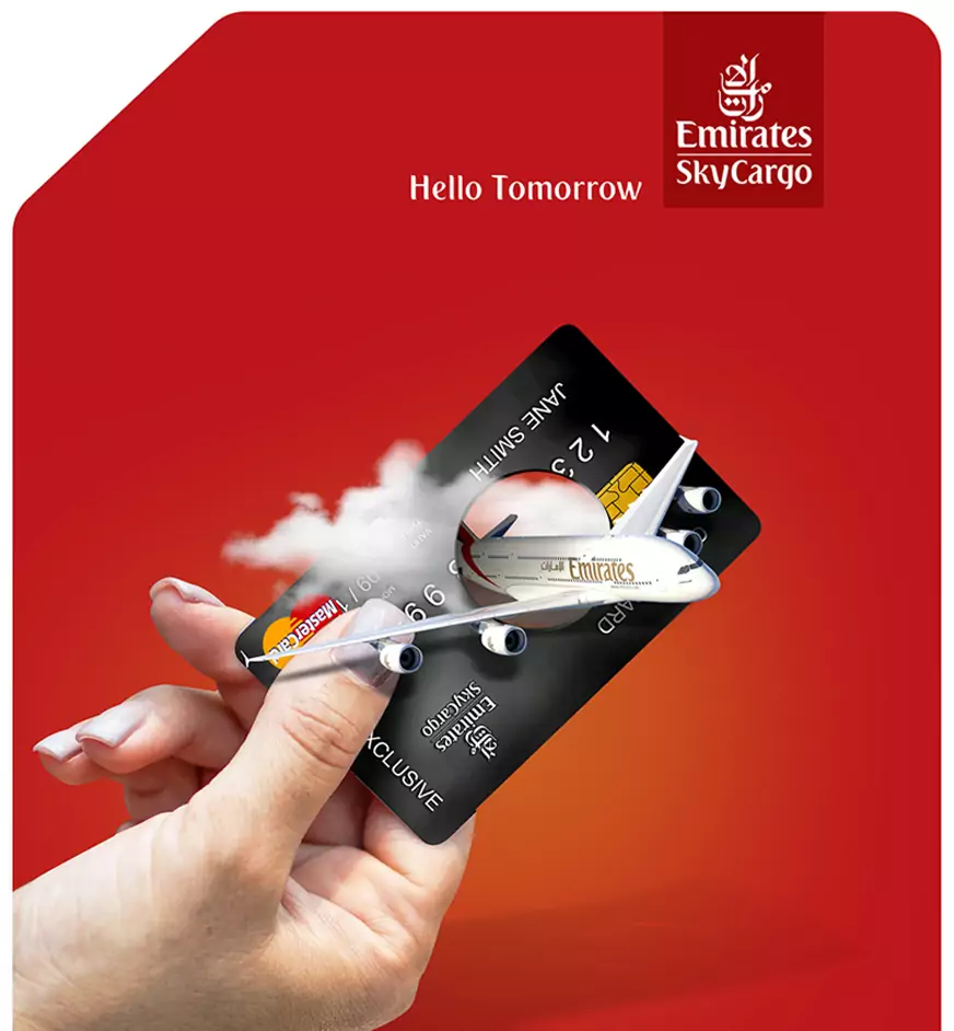 Hand holding an Emirates credit card with a 3D airplane emerging through clouds