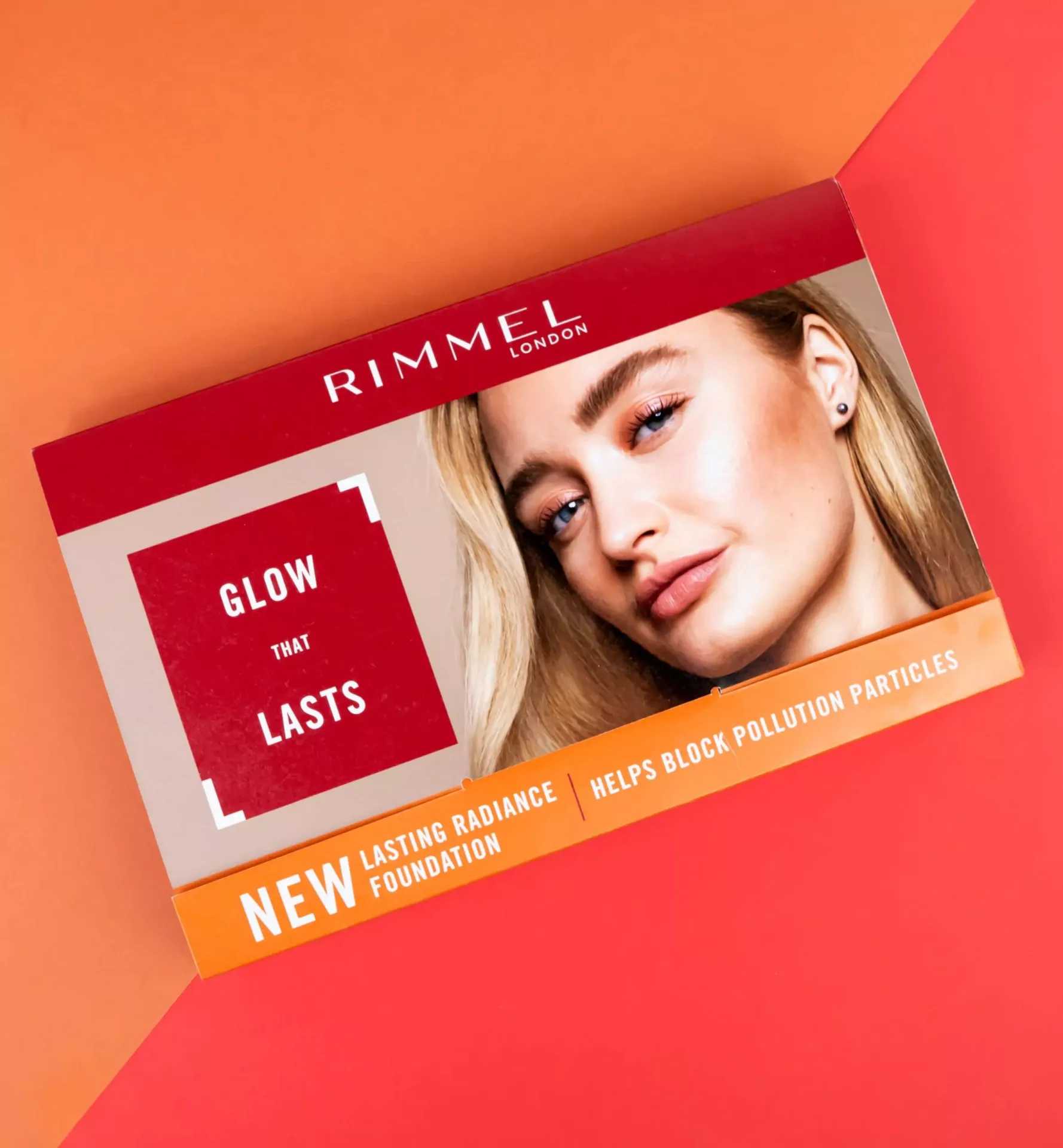 Rimmel Lasting Radiance Foundation promotional box featuring a female model with red and yellow background