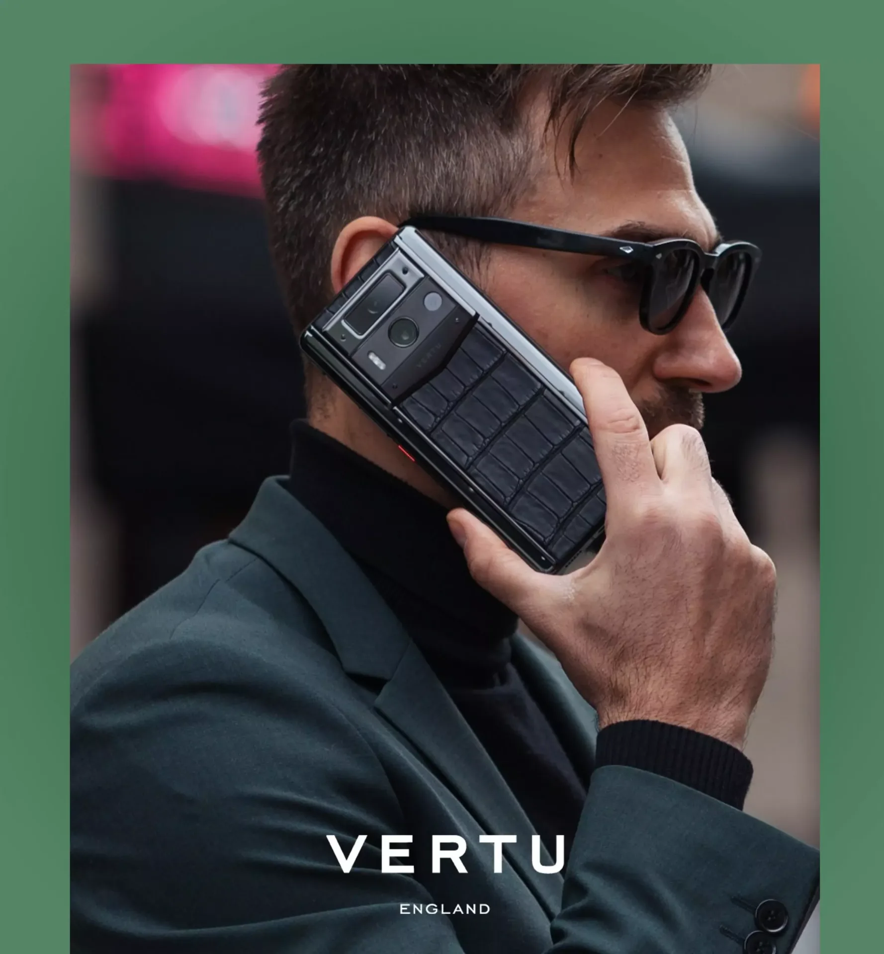 Man wearing sunglasses holding a black leather-textured Vertu luxury smartphone to his ear
